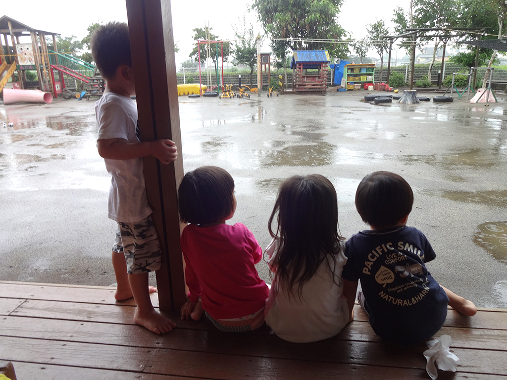 所沢市のあかね保育園の園庭でテラスで雨宿りする画像