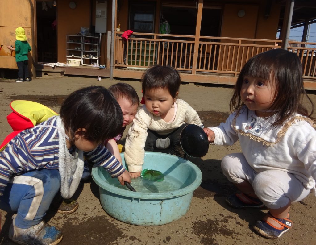 所沢市のあかね保育園の園庭で水遊びをする子どもの画像